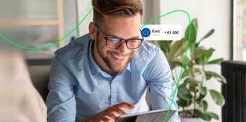 A smiling man tapping on a tablet screen