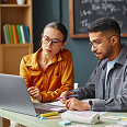 Colleagues communicate using a shared laptop