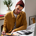 A man at his desk choosing a fabric color