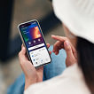 A girl holds a smartphone with the Wallester app open