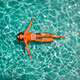 girl in orange swimsuit swims in water
